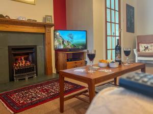 a living room with a fireplace and a tv at Hill Cottage, Braithwaite in Braithwaite