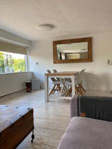 a living room with a table and a mirror at Smalland Loosdrecht Amsterdam in Loosdrecht