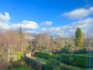 a view of a garden with bushes and trees at Hill Cottage, Braithwaite in Braithwaite