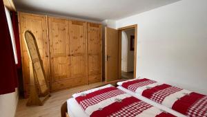 a bedroom with a bed and wooden cabinets at Ferienwohnung mit idyllischer Aussicht in Klosters