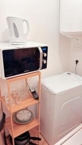 a microwave sitting on a shelf next to a washing machine at Fleur de sel studio in Tarascon