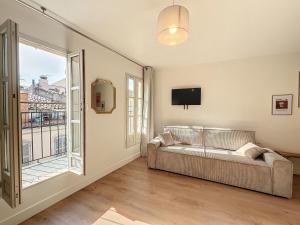 - un salon avec un canapé et une grande fenêtre dans l'établissement Charmant Appartement - Avec Balcon & Lumineux - Les Frères de la Loc', à Marseille