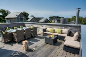 a patio with chairs and a table on a deck at House 12 in Looe