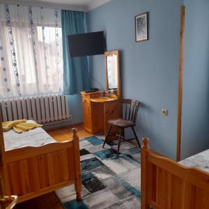 a bedroom with two beds and a mirror and a chair at Mama Emiliya Guest House in Beli Iskar