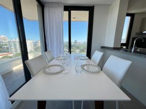 a white table with white chairs and glasses on it at View Luxury in Punta del Este