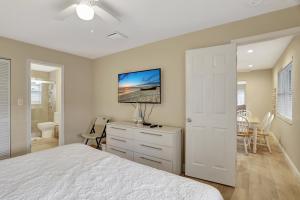 a bedroom with a bed and a desk with a tv at Endless Summer in Pompano Beach