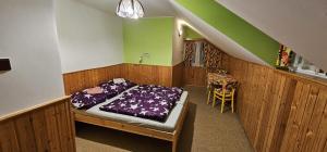 a bedroom with a bed in a room with green walls at Pension u Havrana in Jetřichovice