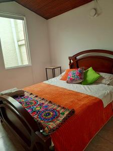 a bedroom with a bed with a colorful blanket on it at Kuyay Hostel in Bogotá