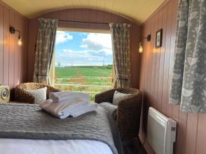 a bedroom with a bed and a window with a view at Ham Hideaway Boutique Glampsite in Kent