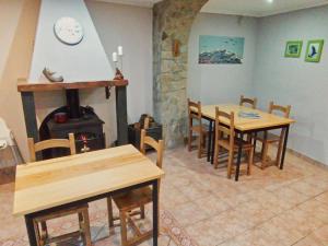 Casa Gerbe في Gerbe: غرفة طعام مع طاولات وموقد خشب