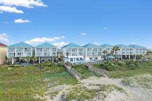 a resort on the beach with a pathway leading to it at Ocean Isle Inn in Ocean Isle Beach