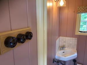 a bathroom with a sink and a toilet and a mirror at Ham Hideaway Boutique Glampsite in Kent