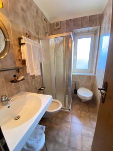 a bathroom with a sink and a shower and a toilet at Affittacamere Garden Cavalese in Cavalese