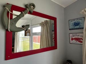 ein Spiegel hängt an einer Wand mit einem Schuhreflex. in der Unterkunft Modern Funky Private Chalet at the Beach in Tywyn