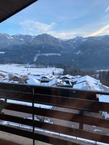 a view from a balcony of a town with snow covered mountains at Affittacamere Garden Cavalese in Cavalese