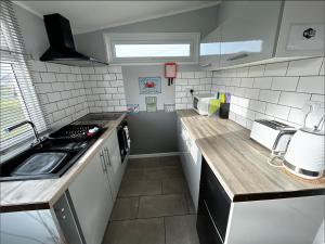 eine Küche mit einer Spüle und einer Arbeitsplatte in der Unterkunft Modern Funky Private Chalet at the Beach in Tywyn