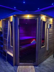 穆斯克龍的住宿－Spazuroom Luxury Suite，一间室内带紫色灯的木制桑拿房