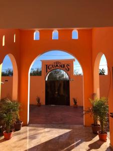 un edificio naranja con una entrada con un cartel en él en Tres Iguanas Apart Hotel - New, cozy & spacious flats, short walk to beach, en Loreto