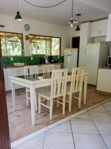 インビトゥバにあるLagoa Hospedariaのキッチン(白いテーブル、椅子付)