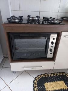 a microwave oven with a stove on top of it at Quarto privativo em casa de condomínio in Cuiabá