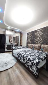 a bedroom with a black and white bed and a mirror at Квартира in Bender