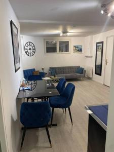 ein Wohnzimmer mit einem Tisch und blauen Stühlen in der Unterkunft Porte de Paris- les Puces in Saint-Ouen