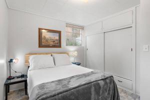a white bedroom with a bed and a window at Cozy Holiday Hideaway King Bed Free Parking in Boise