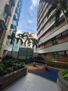 um parque infantil no meio de um edifício com palmeiras em J&G House em Manila