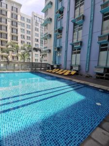 uma grande piscina em frente a alguns edifícios em J&G House em Manila