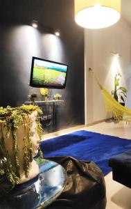 a living room with a tv and a blue carpet at Hermoso Dúplex Independiente como una CASA in Santa Cruz de la Sierra