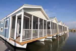 a row of houses on a dock on the water at Blufin Bungalows & Marina in Chincoteague