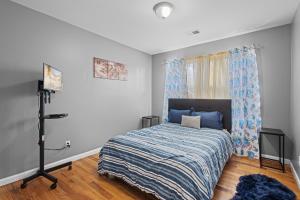 a bedroom with a bed with a blue comforter at FaithInn - 3 Bed 2 Bath Near EWR/ Downtown/ NYC in Newark