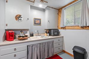 eine Küche mit einer Spüle und einer Mikrowelle in der Unterkunft Exquisite Haven Min To Dt,bsu,& Apt Parking in Boise