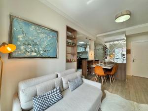 uma sala de estar com um sofá e uma mesa em Morada Real 405 - Apê novo no Centro de Canela em Canela