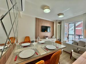 uma sala de jantar e sala de estar com mesa e cadeiras em Morada Real 405 - Apê novo no Centro de Canela em Canela