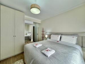 um quarto com uma cama grande e toalhas em Morada Real 405 - Apê novo no Centro de Canela em Canela