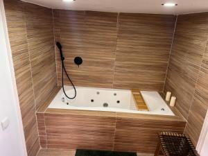 a bath tub in a bathroom with wooden walls at Prince of Beer Sheva by CROWN in Beer Sheva