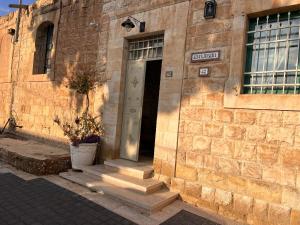 um edifício de tijolos com uma porta e um vaso de plantas em Prince of Beer Sheva by CROWN em Bersebá