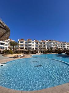 una gran piscina frente a algunos edificios de apartamentos en Studio on the ground floor in Sharm Hills Resort with private garden and pool view, en Sharm El Sheikh