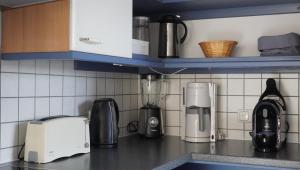 a kitchen counter with appliances on a counter top at Das Neukirchen Inn in Neuburg am Inn