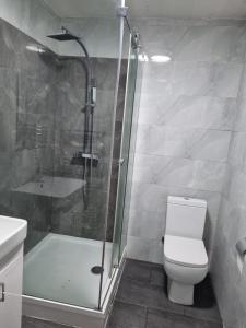 uma casa de banho com um chuveiro, um WC e um lavatório. em Excellent stay em Leicester