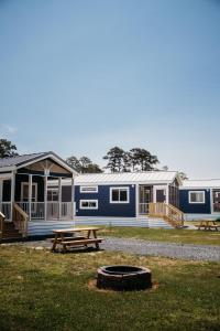 uma casa azul e branca com uma mesa de piquenique em frente em Sun Outdoors Cape Charles em Cape Charles