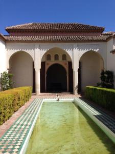 La Bella escondida piscina golf solarium في مالقة: ساحة مع نافورة أمام المبنى