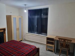a bedroom with a bed and a desk and a window at Excellent stay in Leicester