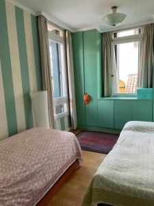 a bedroom with green walls and a bed and a window at Zattere apartment - Casa Gardella in Venice