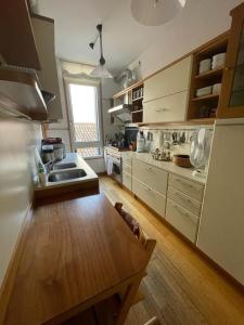 a large kitchen with a wooden floor and a table at Zattere apartment - Casa Gardella in Venice