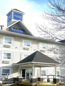a large white building with a sign on it at Travelodge by Wyndham Fort McMurray in Fort McMurray