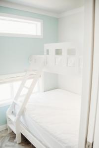 um beliche branco num quarto com uma janela em Sun Outdoors Cape Charles em Cape Charles