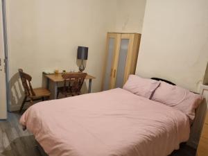 um quarto com uma cama, uma secretária e uma mesa em Excellent stay em Leicester