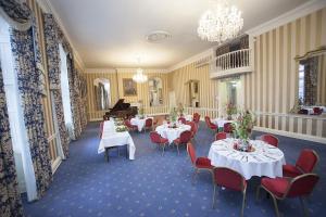 a dining room with tables and chairs and a piano at Norfolk Arms Hotel in Arundel